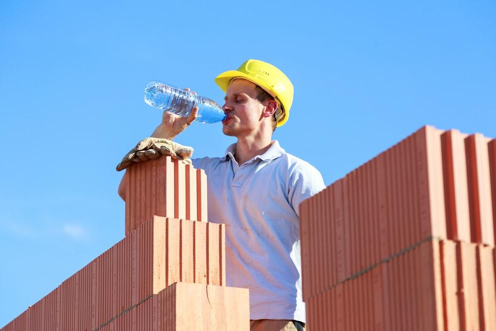 ouvrier qui boit sur un chantier en pleine chaleur
